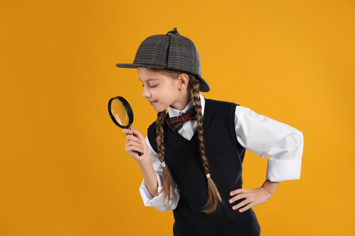 Cute little detective with magnifying glass on yellow background